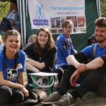 Three smiling events volunteer sitting down at the London Marathon picnic