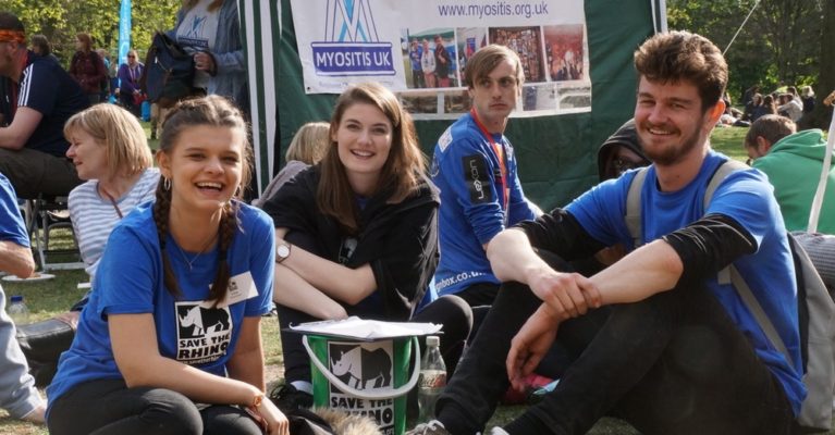 Three smiling events volunteer sitting down at the London Marathon picnic