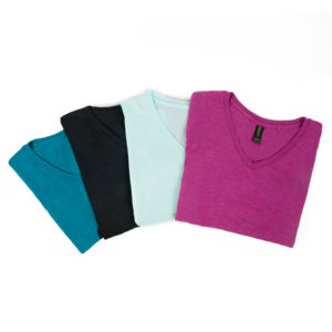 A photograph of four variations of the women's SRI logo t-shirts