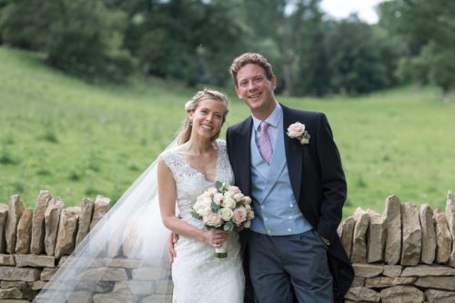 Smiling bride and groom in a feild