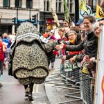 Rhino costume runner high fives spectators at the Royal Parks Half Marathon