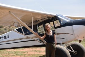 Image of Save the Rhino's Partnerships Manager Michaela next to a small aircraft.