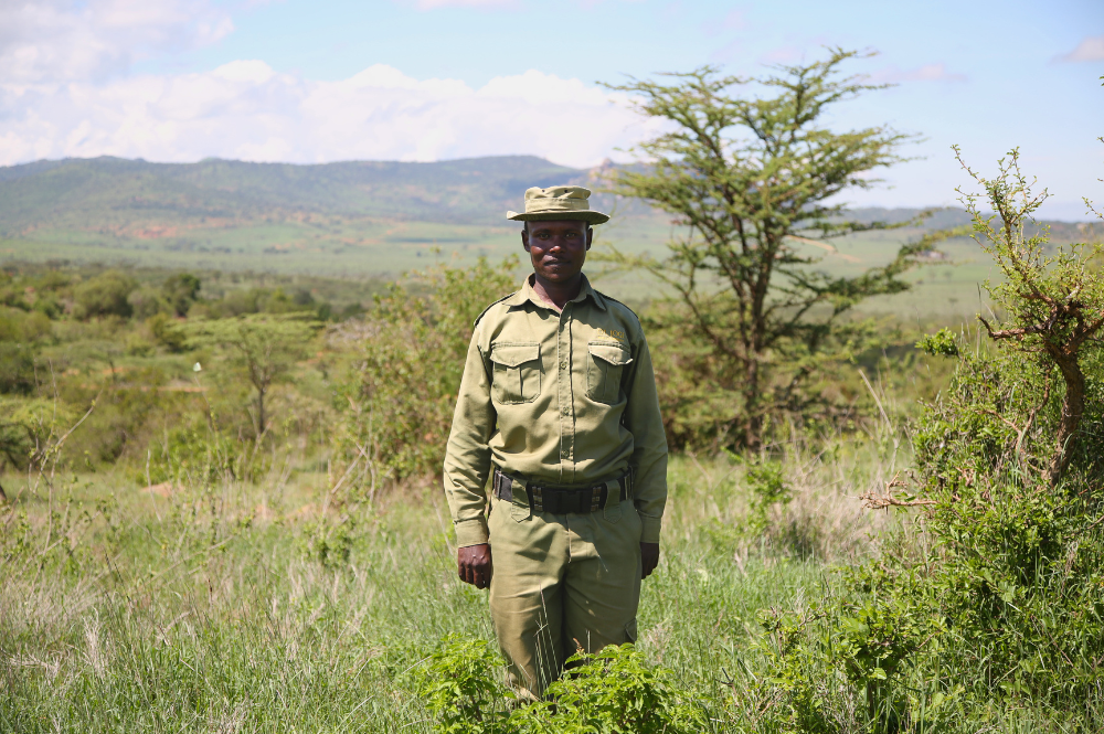 Man in uniform standing outside.