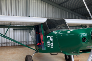 Side of a light aircraft with Save the Rhino logo on the side.