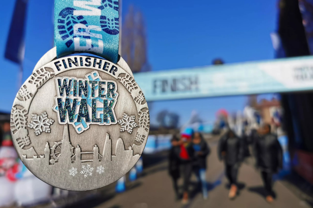 A Winter Walk medal with the finish line in the background