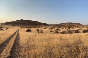View of Kunene desert landscape with vehicle tracks.